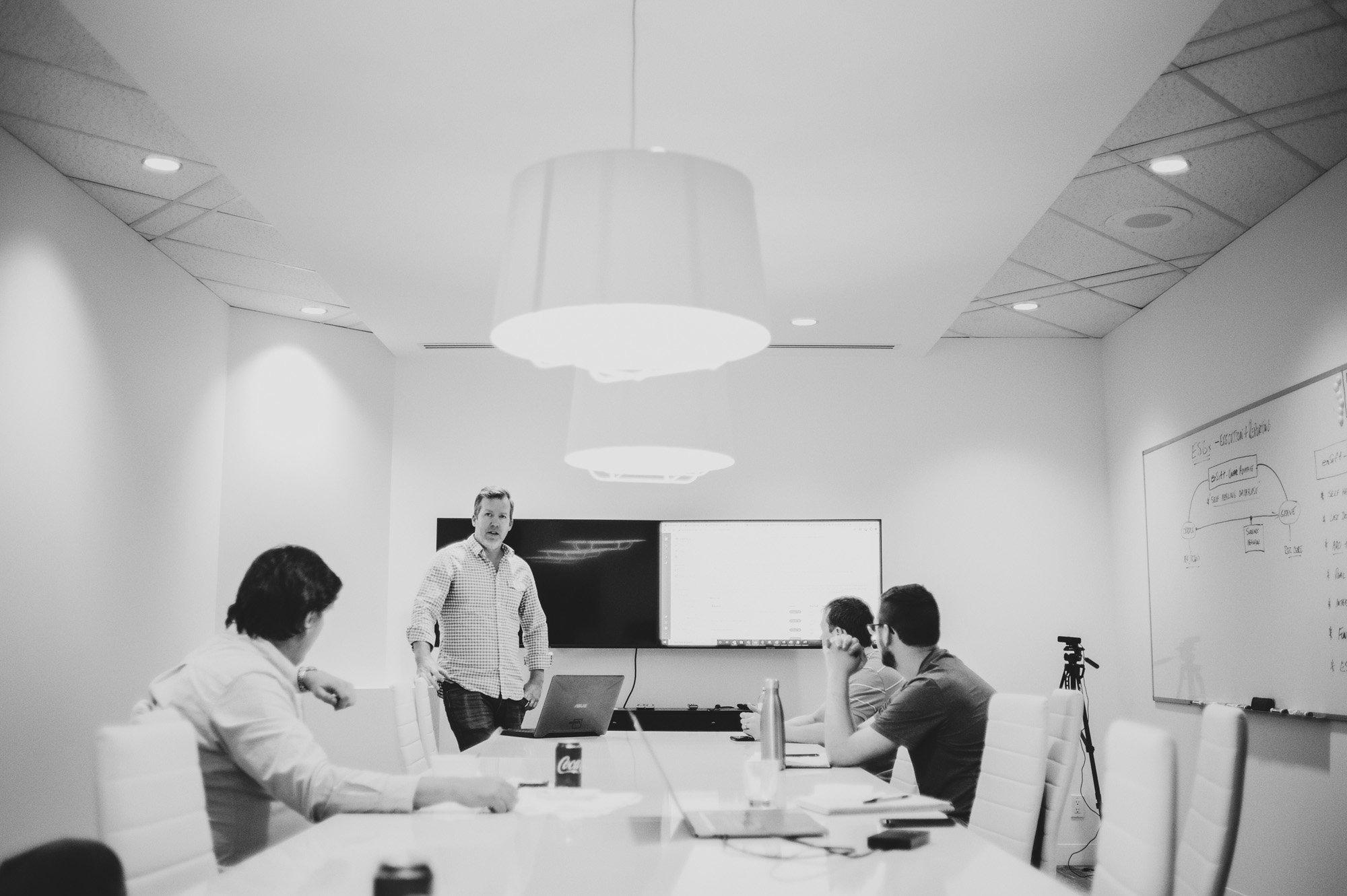 Team discovery session in a boardroom with early enSift concepts sketched on a whiteboard